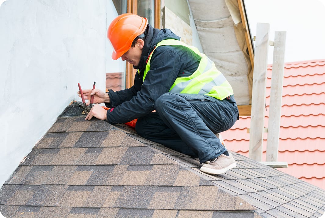 Roofer working on shingled roof