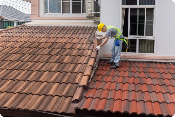 Worker repairing roof tiles