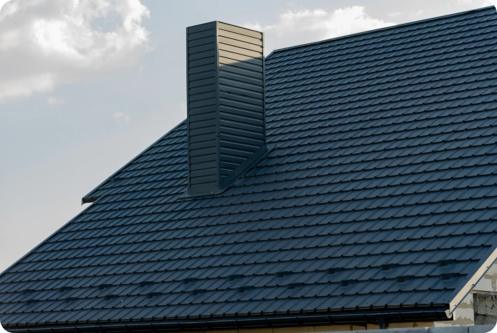 Dark tiled rooftop under cloudy sky